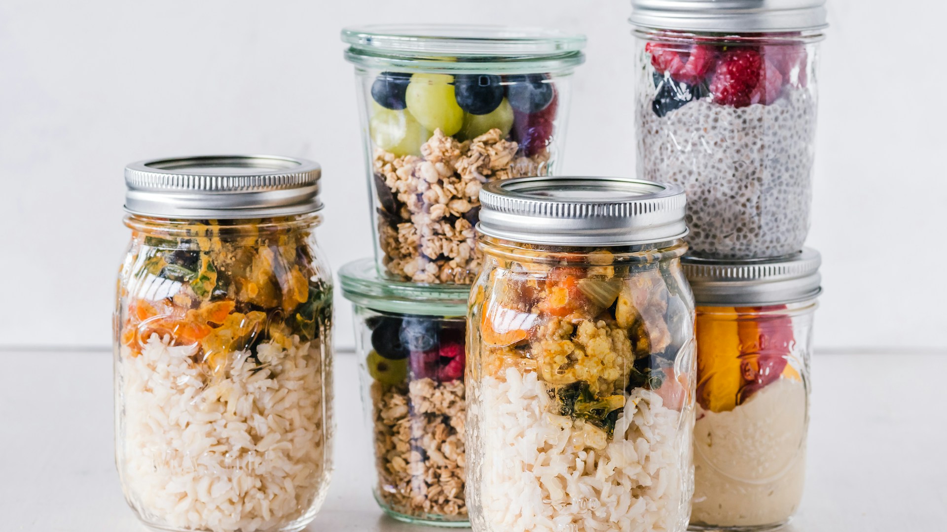 six full clear glass jars on white surface