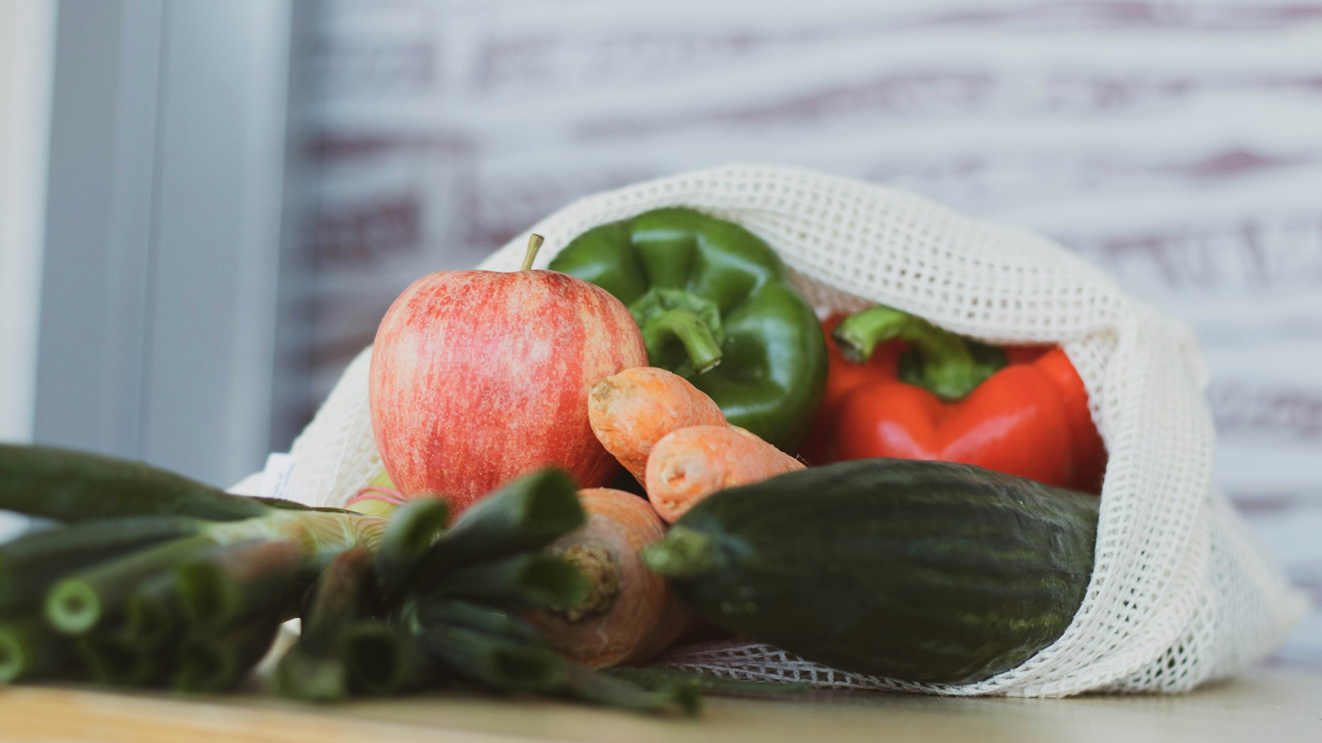 red tomato beside green vegetable on white table