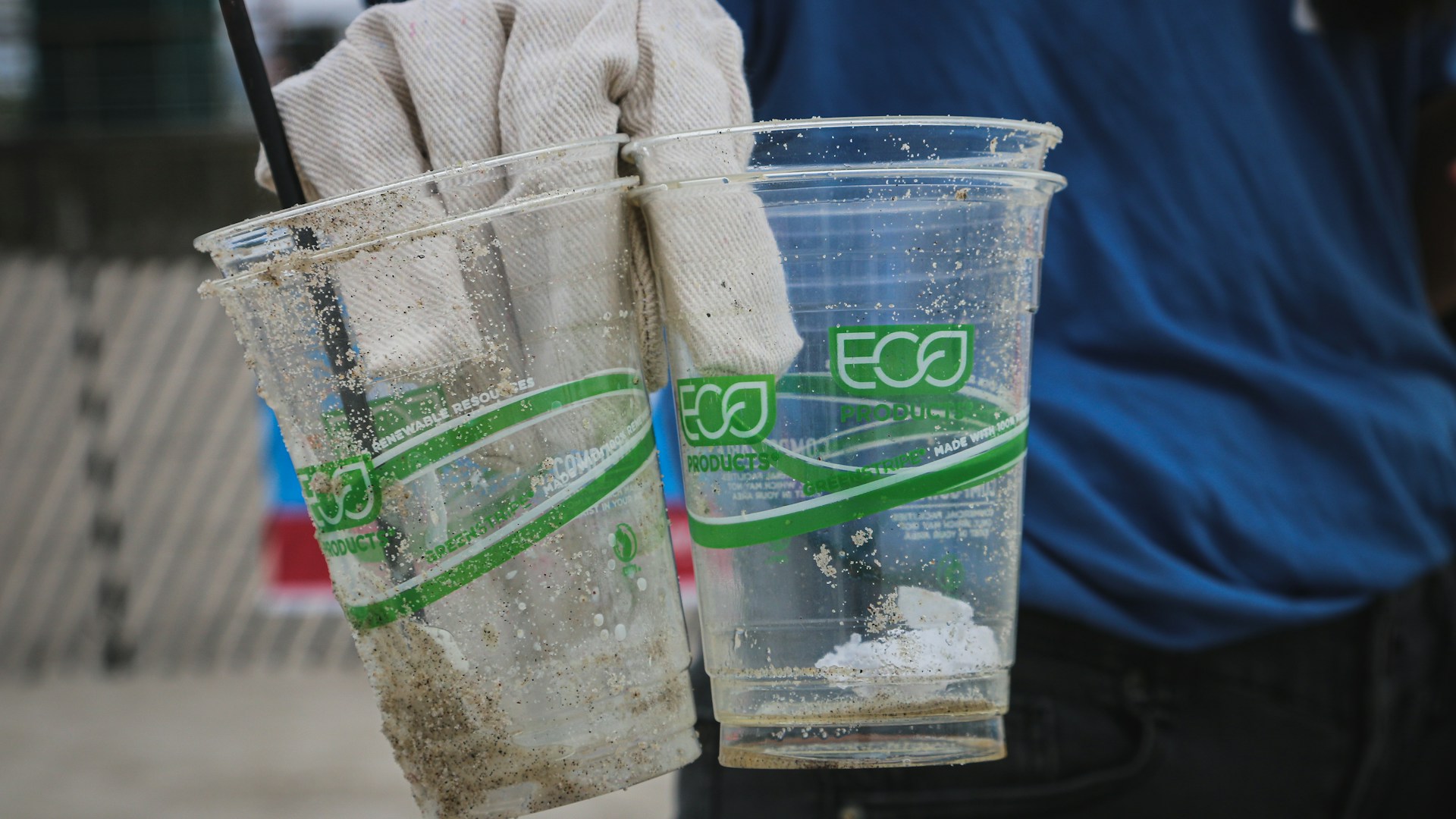 person holding two clear plastic disposable cups