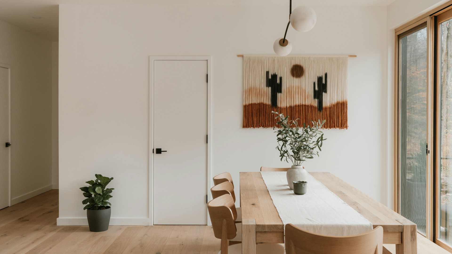Modern dining room with desert-themed wall hanging.