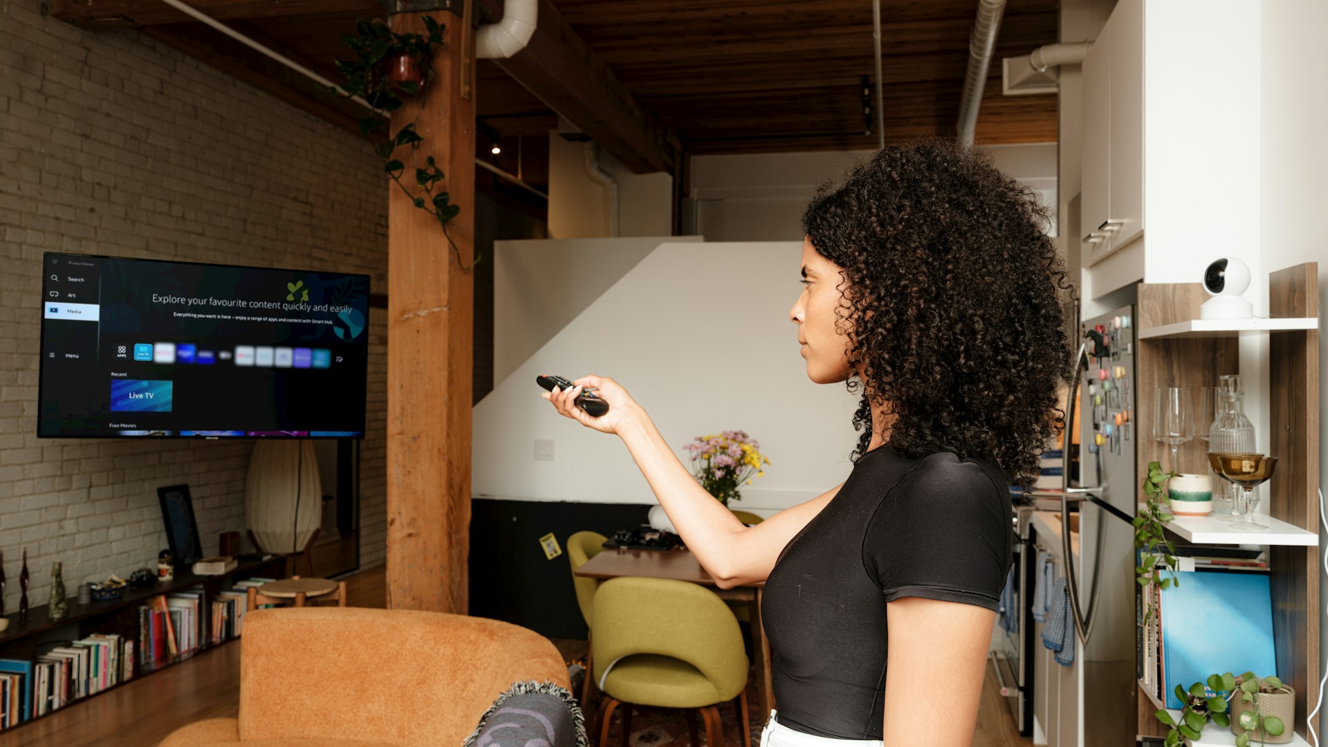 A woman standing in a living room holding a remote