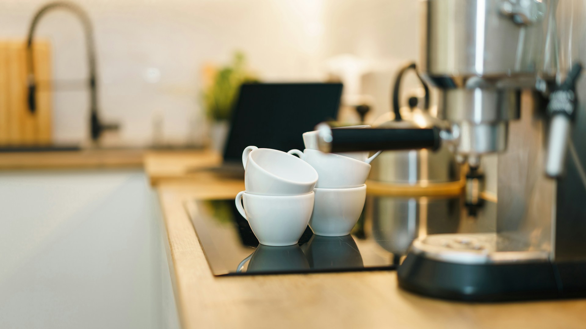 Coffee machine and cups on a modern kitchen counter.