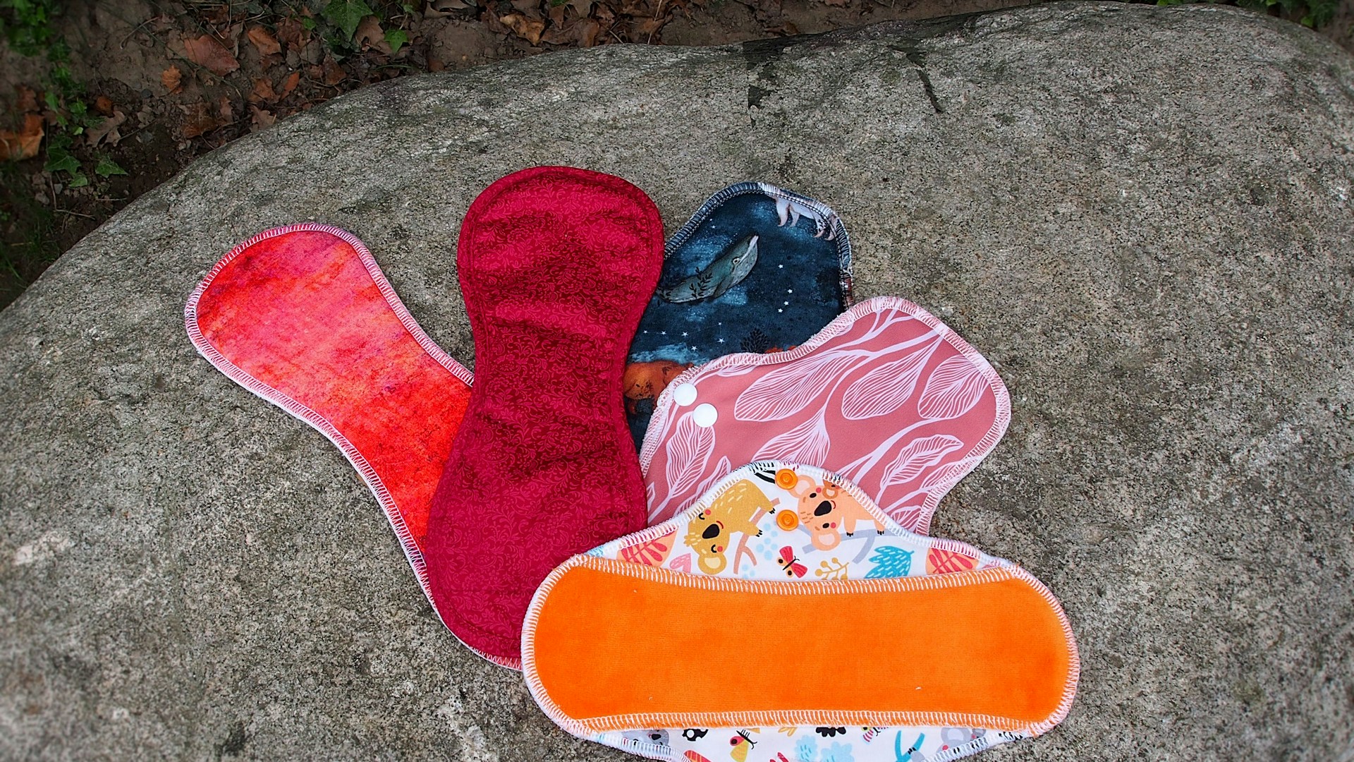a pair of oven mitts sitting on top of a rock