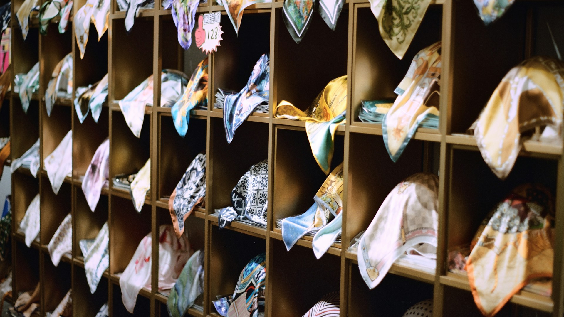 Colorful handkerchiefs neatly folded on wooden shelves