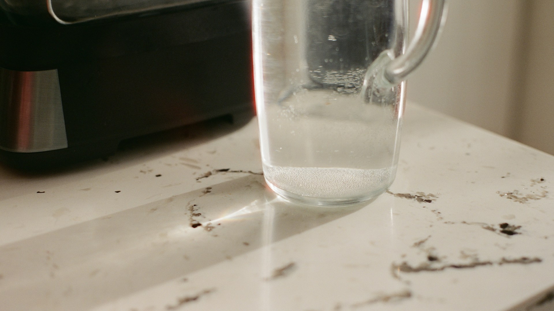 Clear glass pitcher with water on a countertop.