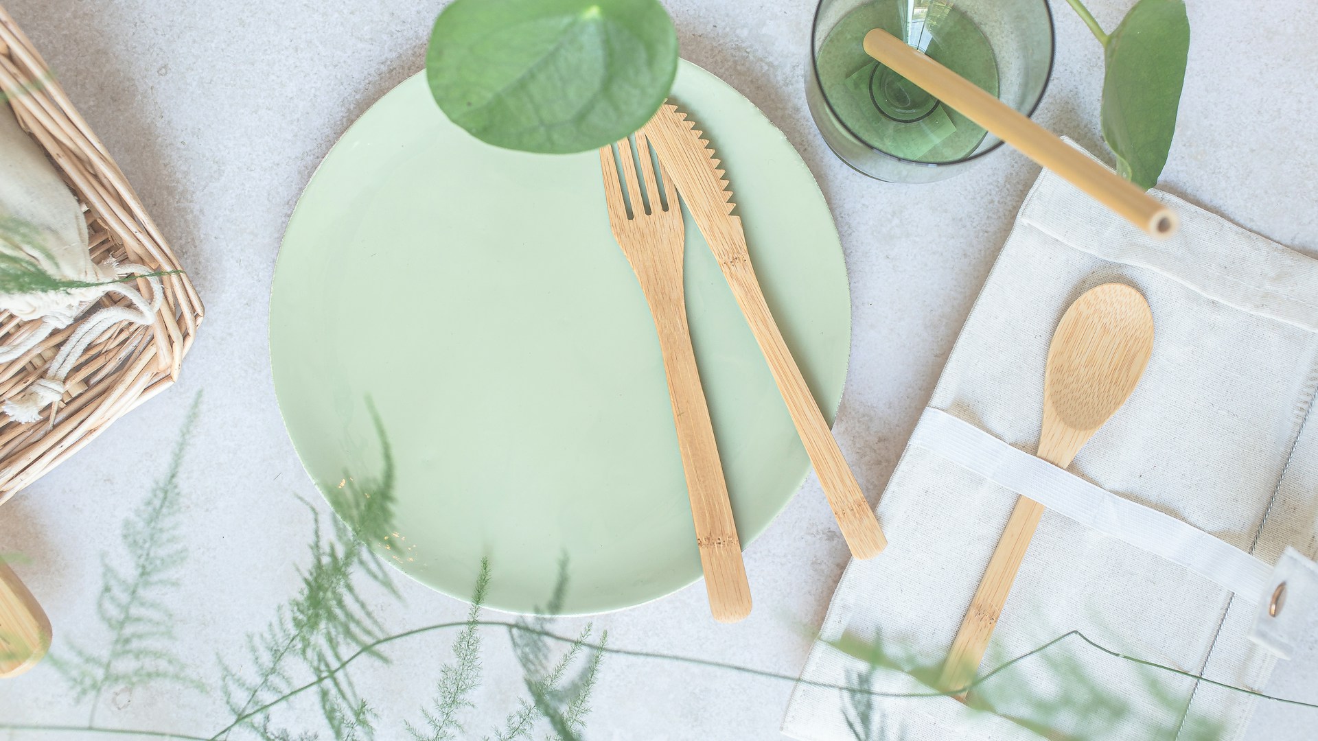 a green plate with wooden utensils on it