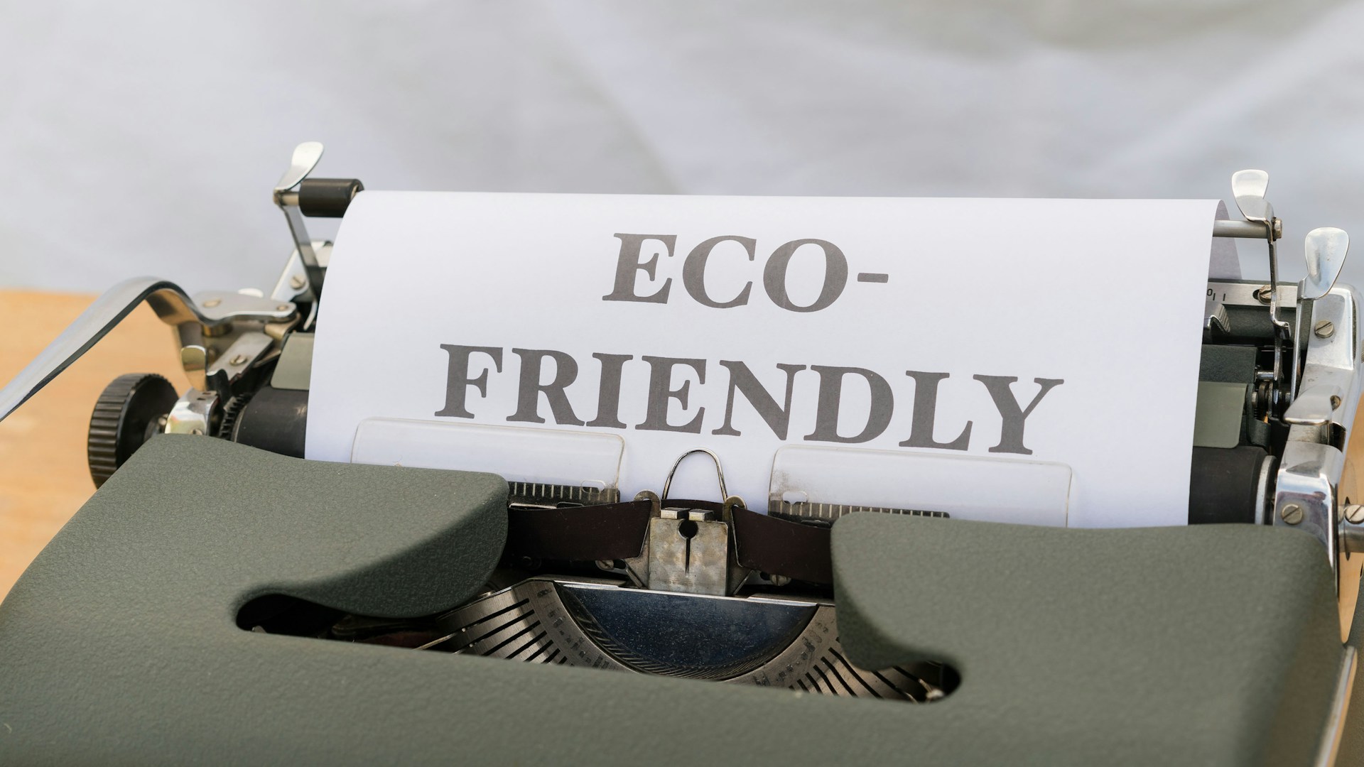 a close up of a typewriter with a paper that reads eco - friendly